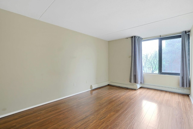 unfurnished room with baseboards and wood finished floors