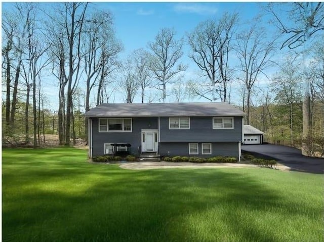 split foyer home featuring a detached garage, entry steps, and a front yard