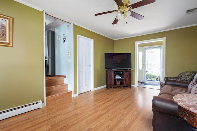 living area with ornamental molding, baseboard heating, light wood-type flooring, and visible vents
