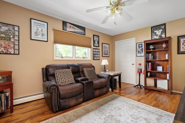 living room with ceiling fan, baseboard heating, and wood finished floors