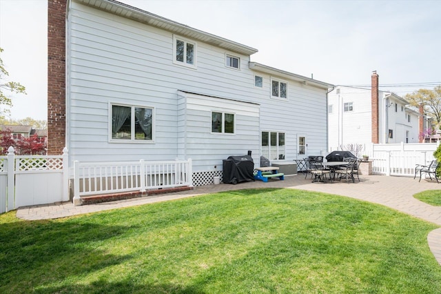 rear view of property featuring a patio, a fenced backyard, and a yard