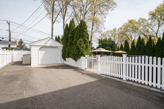 detached garage with fence and driveway