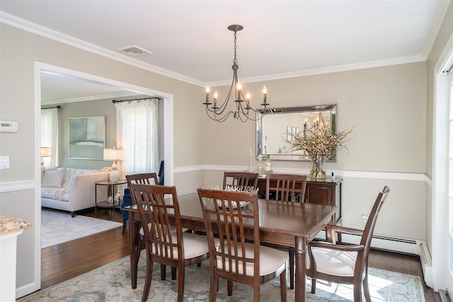 dining space with crown molding, wood finished floors, a chandelier, and visible vents