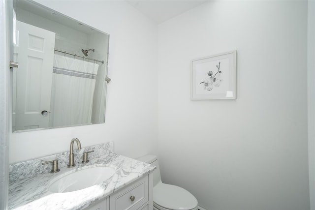 bathroom featuring toilet, a shower with curtain, and vanity