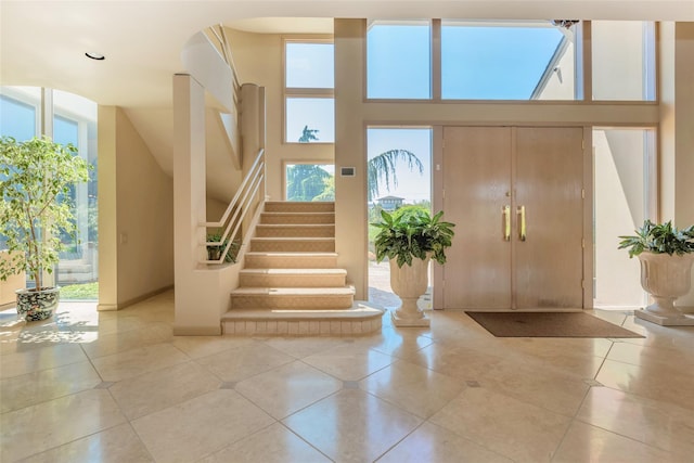 136 The Helm, East Islip, NY 11730 - entrance foyer with light tile patterned floors, stairs, and a high ceiling