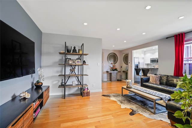 living area with recessed lighting, light wood-style flooring, and baseboards