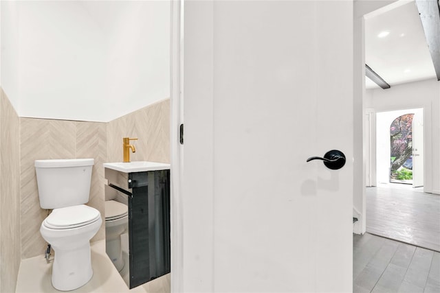 179-55 Anderson Rd, Jamaica, NY 11434 - bathroom with toilet, a wainscoted wall, tile walls, and wood finished floors