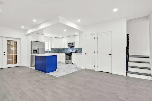 179-55 Anderson Rd, Jamaica, NY 11434 - kitchen featuring white cabinets, appliances with stainless steel finishes, light countertops, a center island, and recessed lighting