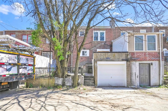 179-55 Anderson Rd, Jamaica, NY 11434 - back of property with a garage, brick siding, and driveway
