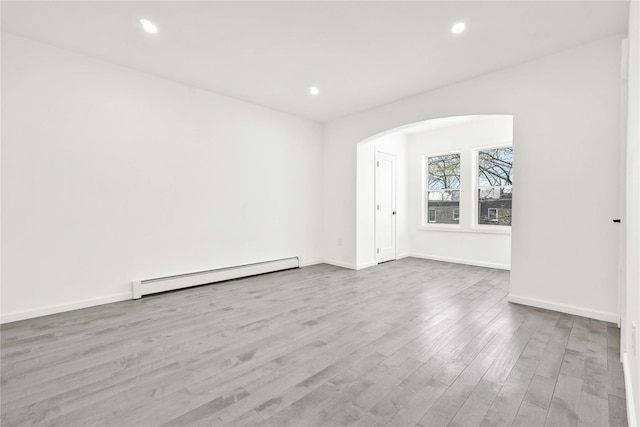179-55 Anderson Rd, Jamaica, NY 11434 - empty room with baseboard heating, baseboards, arched walkways, recessed lighting, and wood finished floors