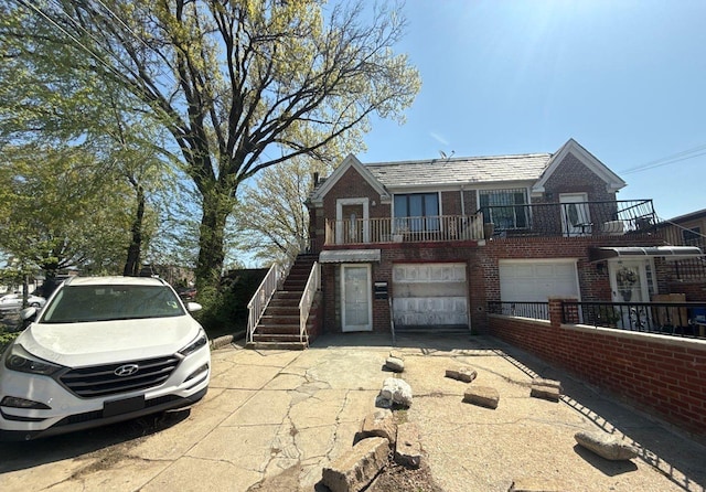 view of front of home featuring driveway, stairway, brick siding, and a garage
