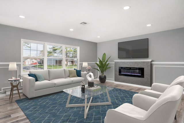living area with recessed lighting, wood finished floors, and visible vents