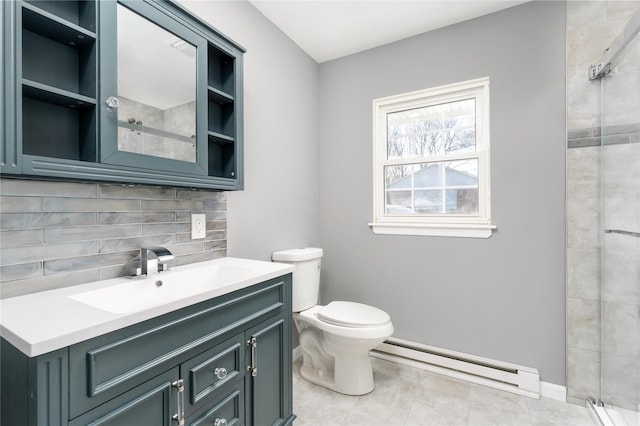 bathroom featuring vanity, toilet, baseboard heating, backsplash, and a tile shower