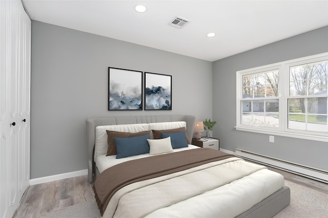 bedroom featuring recessed lighting, baseboards, wood finished floors, a baseboard radiator, and visible vents