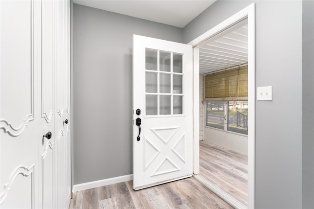 entryway featuring baseboards and wood finished floors