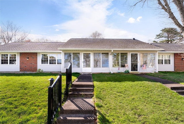 ranch-style house with a sunroom and a front lawn