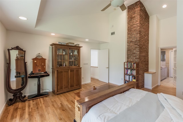 bedroom featuring visible vents, baseboards, wood finished floors, and high vaulted ceiling