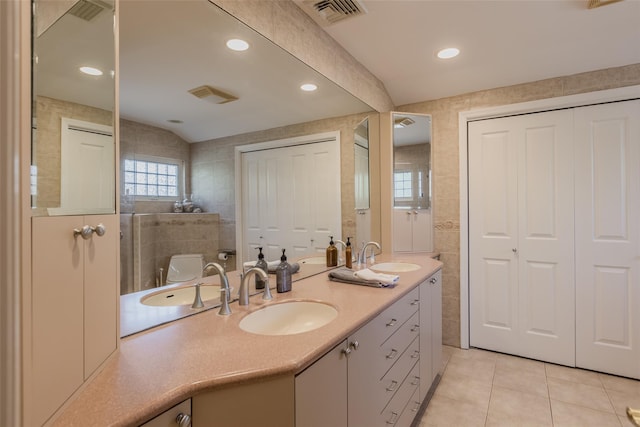full bath featuring tile patterned flooring, a sink, visible vents, and tile walls