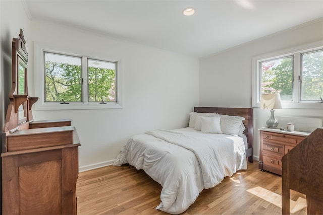 bedroom with crown molding, baseboards, light wood-style floors, and recessed lighting