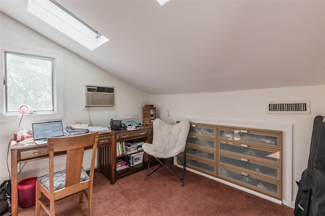 carpeted home office with visible vents, a wall unit AC, and vaulted ceiling with skylight