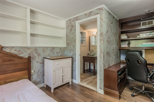 interior space featuring a sink, ornamental molding, wallpapered walls, and wood finished floors