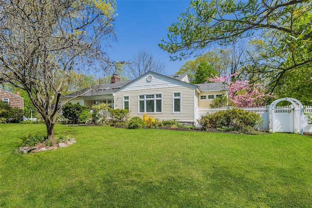 view of front facade featuring a garage, a front lawn, fence, and a chimney