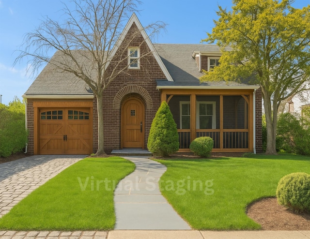 444 W Olive St, Long Beach, NY 11561 - english style home with roof with shingles, an attached garage, a front lawn, brick siding, and driveway