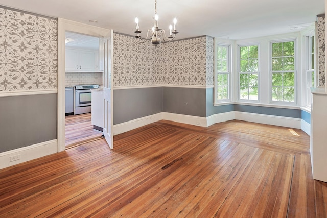 27 Bedford Rd, Pleasantville, NY 10570 - unfurnished dining area featuring wallpapered walls, wainscoting, a chandelier, and wood-type flooring