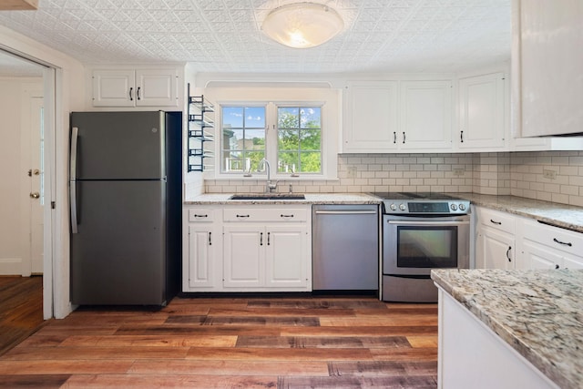 27 Bedford Rd, Pleasantville, NY 10570 - kitchen featuring appliances with stainless steel finishes, an ornate ceiling, backsplash, white cabinets, and dark wood-style flooring