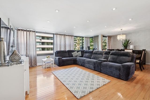 living room featuring recessed lighting, light wood finished floors, and an inviting chandelier