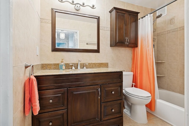 bathroom with shower / bath combination with curtain, tile walls, vanity, tile patterned floors, and toilet