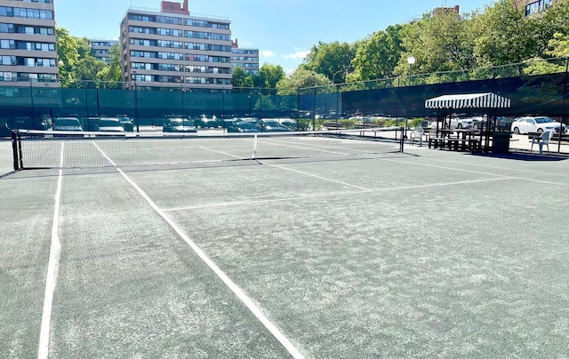 view of tennis court featuring fence
