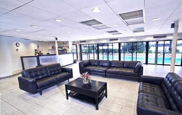 tiled living room with a drop ceiling and recessed lighting