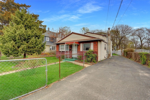 bungalow featuring driveway, a chimney, fence private yard, and a front yard
