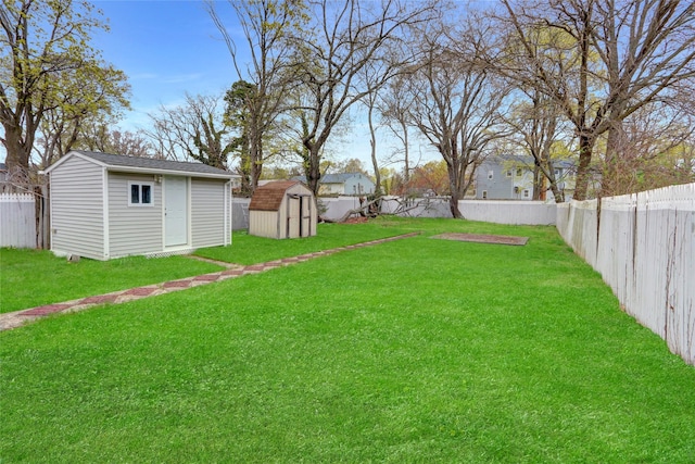 view of yard featuring a fenced backyard, a storage unit, and an outbuilding