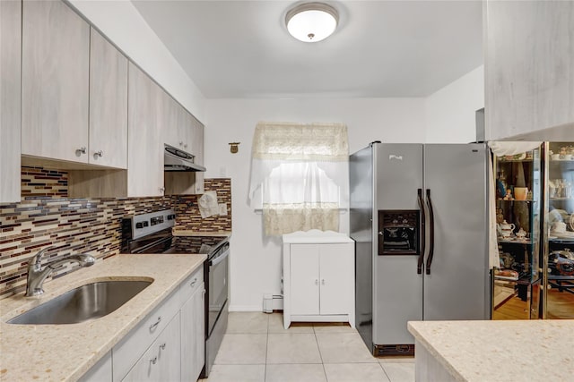 kitchen with decorative backsplash, under cabinet range hood, a sink, light tile patterned floors, and stainless steel appliances