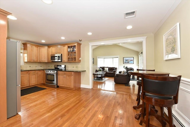 kitchen with light wood finished floors, visible vents, appliances with stainless steel finishes, and dark countertops