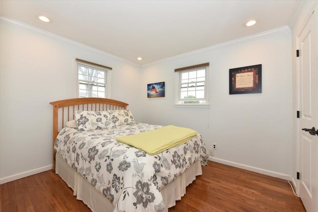 bedroom with baseboards, wood finished floors, and multiple windows