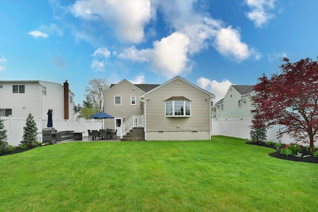 rear view of property with a yard, crawl space, and a fenced backyard