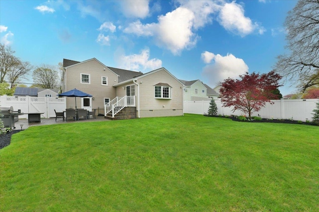 rear view of house featuring a fenced backyard, a yard, a patio area, and crawl space