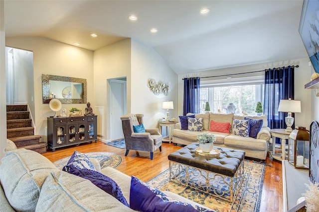 living room featuring recessed lighting, vaulted ceiling, wood finished floors, and stairway