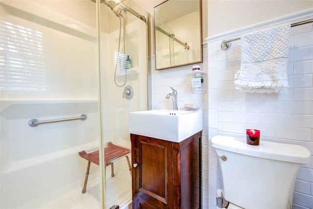 bathroom featuring vanity, toilet, tile walls, backsplash, and a stall shower