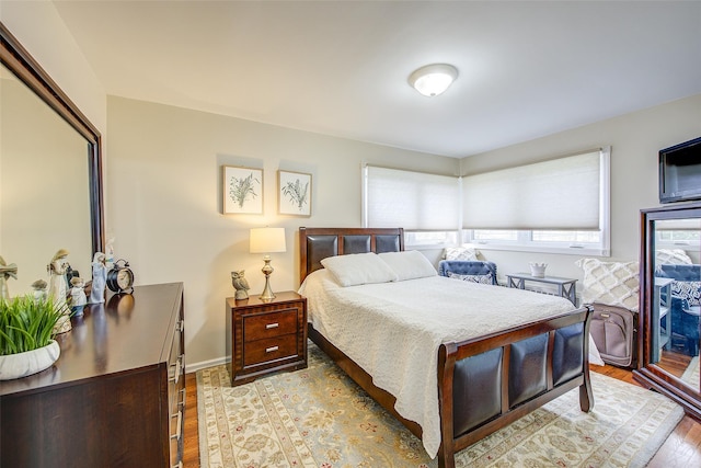 bedroom featuring baseboards and light wood finished floors