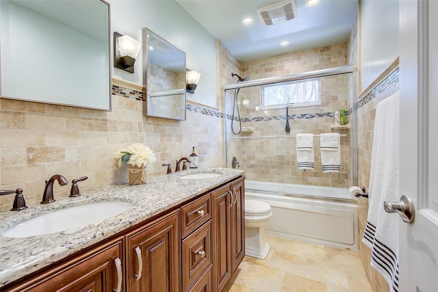 bathroom with toilet, enclosed tub / shower combo, a sink, and visible vents