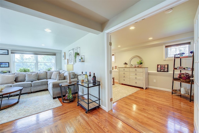 living area with recessed lighting, baseboards, plenty of natural light, and light wood-style flooring