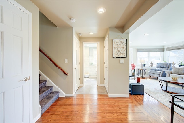 corridor featuring stairway, baseboards, recessed lighting, and light wood-style flooring