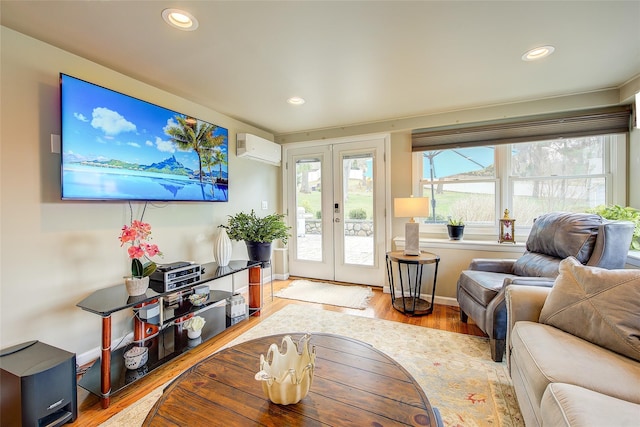 living room featuring recessed lighting, a wall mounted AC, french doors, and light wood-type flooring