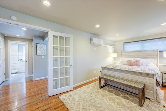 bedroom with recessed lighting, baseboards, an AC wall unit, and light wood-type flooring