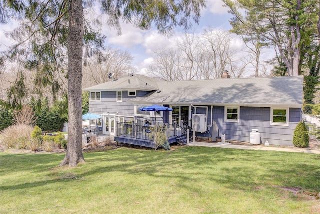 back of house featuring roof with shingles, ac unit, a deck, a chimney, and a yard