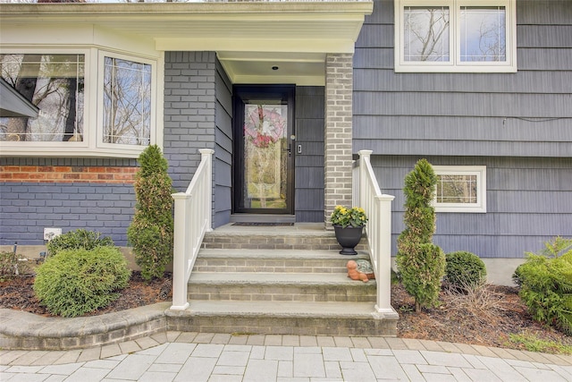 view of exterior entry with brick siding